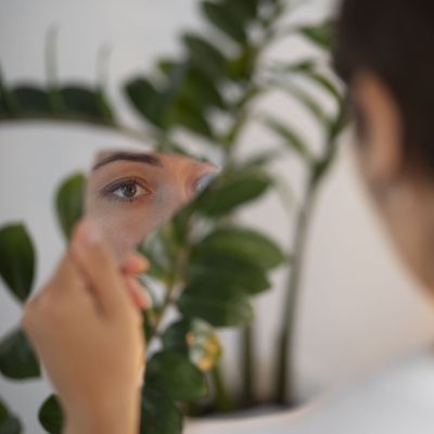 portrait-young-woman-with-low-self-esteem-looking-hand-held-mirror